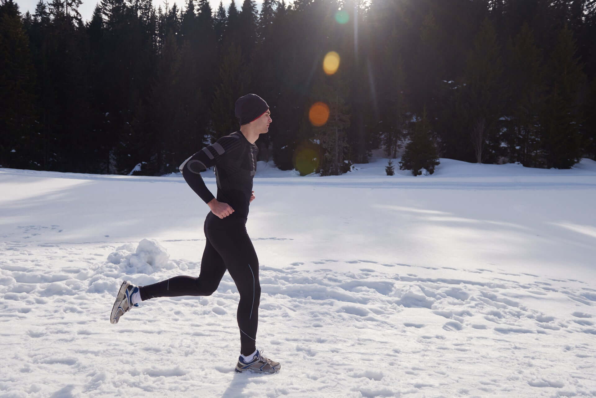 Man running in outdoor snow with leggings, perfect for camping and travel, available at revlando.com.