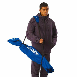 Man carrying Salomon blue ski rack, ideal for outdoor sports and camping adventures.