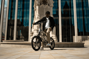 Outdoor shot of a person riding a sleek electric bike in an urban setting, showcasing adventure and travel.