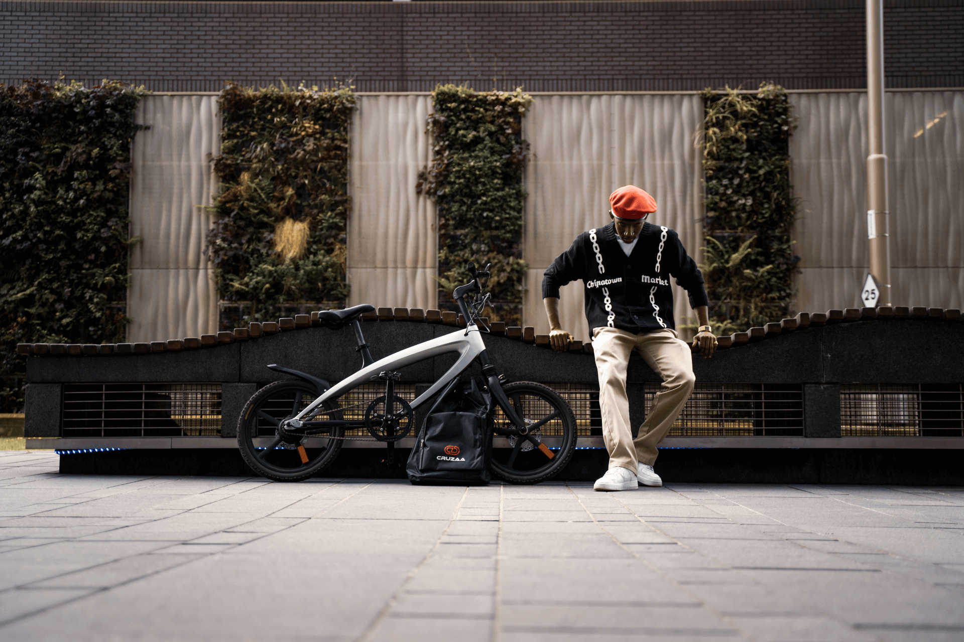 Stylish rider posing beside an official Carbon Black E-Bike, perfect for outdoor adventures and travel.