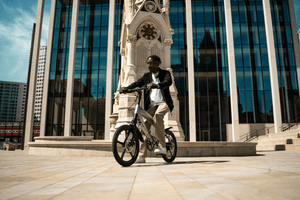 Stylish rider on a gun metal grey e-bike near a modern building, perfect for outdoor adventures.