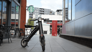 Limited Edition Cruzaa Electric Scooter parked stylishly on a city sidewalk, perfect for outdoor adventures and travel.