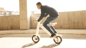 Person riding a stylish electric scooter in an urban setting, showcasing outdoor sport adventure travel.