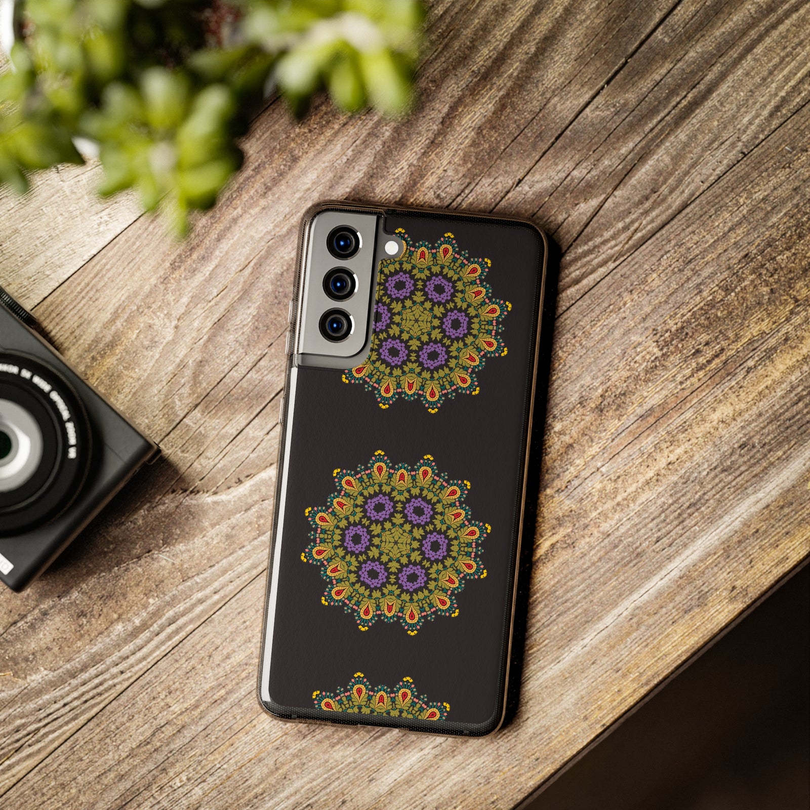Gold mandala phone case on wooden surface, perfect for outdoor adventures and stylish protection at revlando.com.