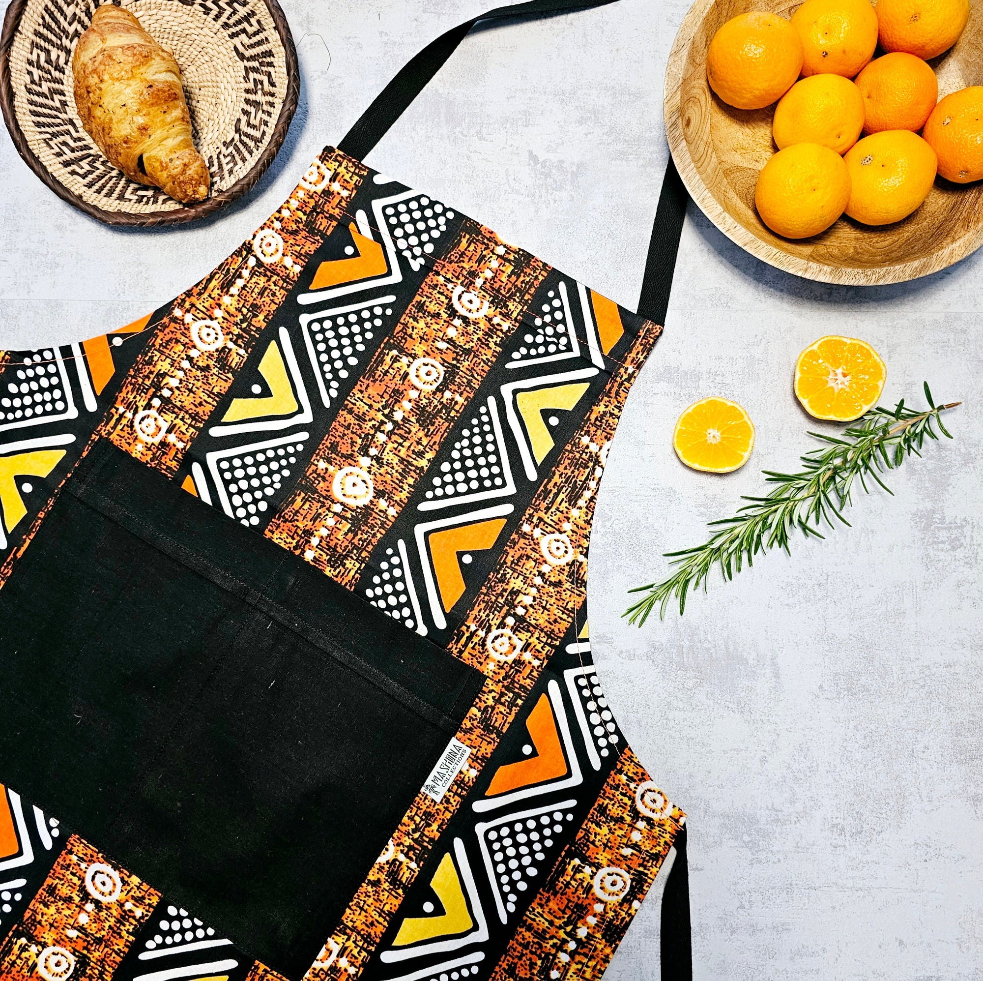 Handmade African print apron with pocket, vibrant colors, perfect for outdoor cooking and camping adventures.