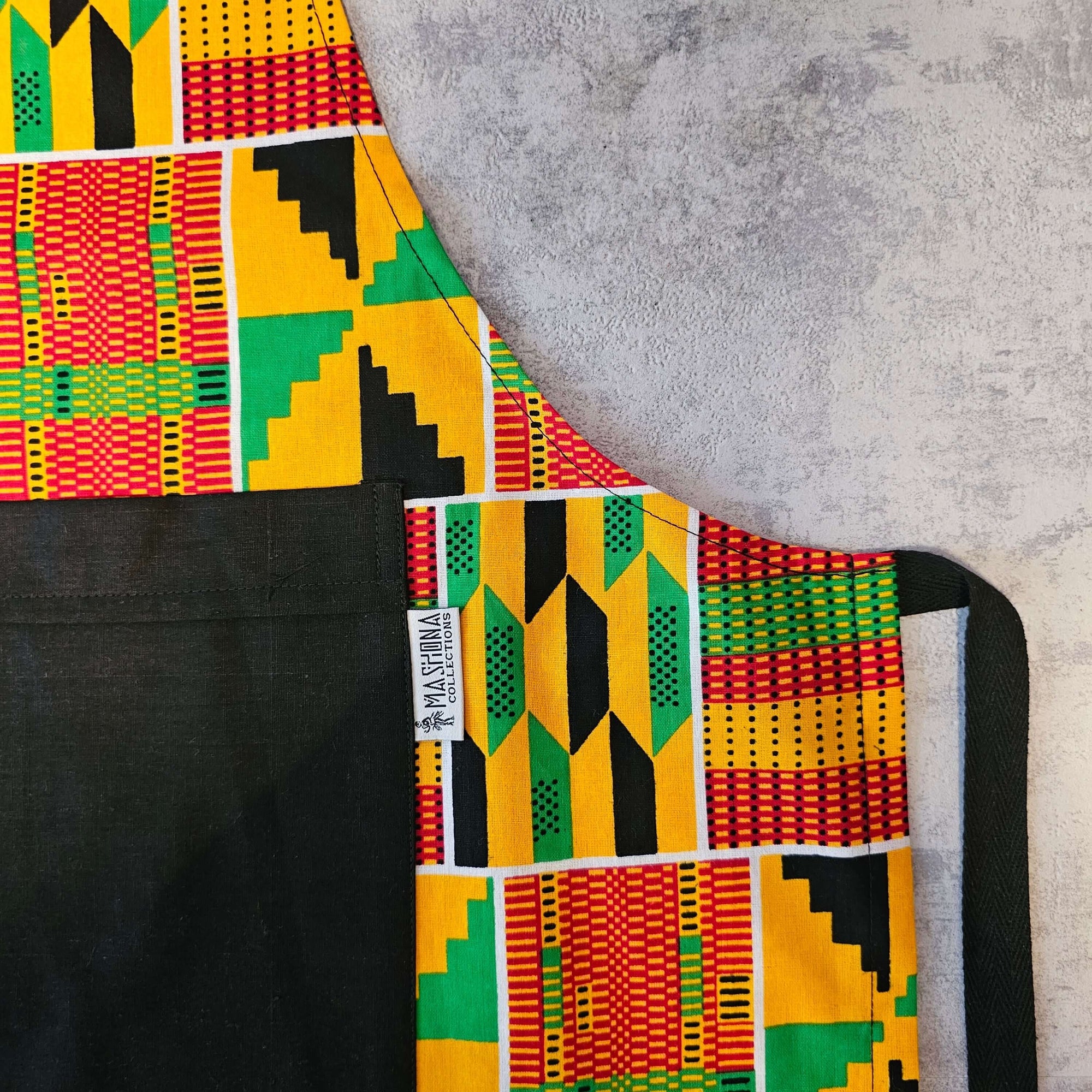 Handmade Kente print apron featuring a pocket, ideal for outdoor cooking and camping adventures.