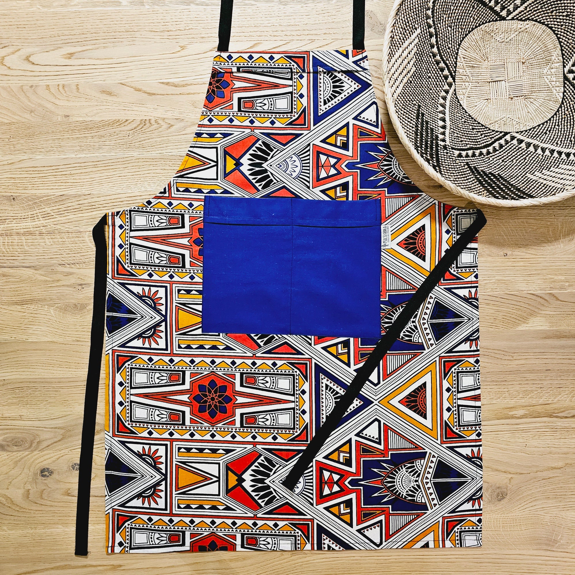 Vibrant handmade African print apron with blue pocket, perfect for outdoor adventures and camping. Available at revlando.com.