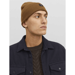 Young man wearing a brown beanie and navy jacket, showcasing a stylish outdoor look for winter adventures.