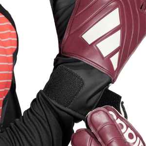 Detail of Adidas Copa Club Goalkeeper Gloves in burgundy, showcasing the secure wrist strap and premium design for sports.