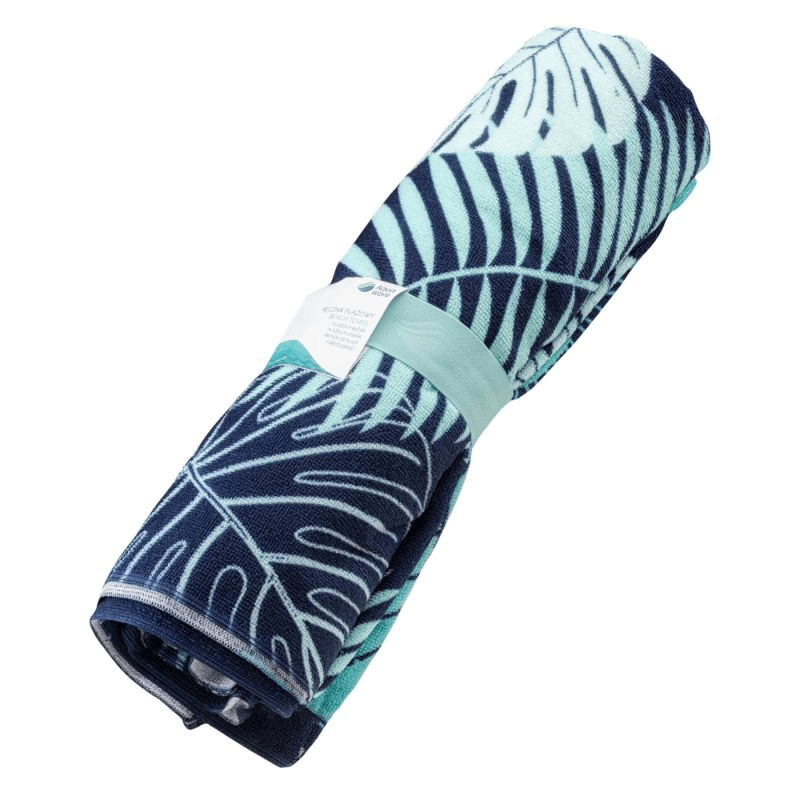 Aquawave Toflo Towel rolled with a tropical leaf design, lightweight, quick-drying, perfect for outdoor adventures.