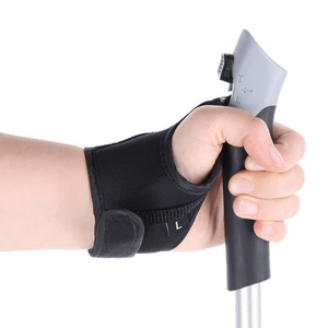 Hand gripping the ergonomic handle of Nordic walking poles with adjustable wrist strap for comfort and support in outdoor activities.