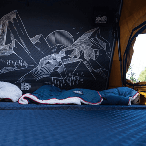 Interior view of Offlander Fold 2 Sand Roof Tent, showcasing cozy bedding and mountain-themed design for outdoor adventures.