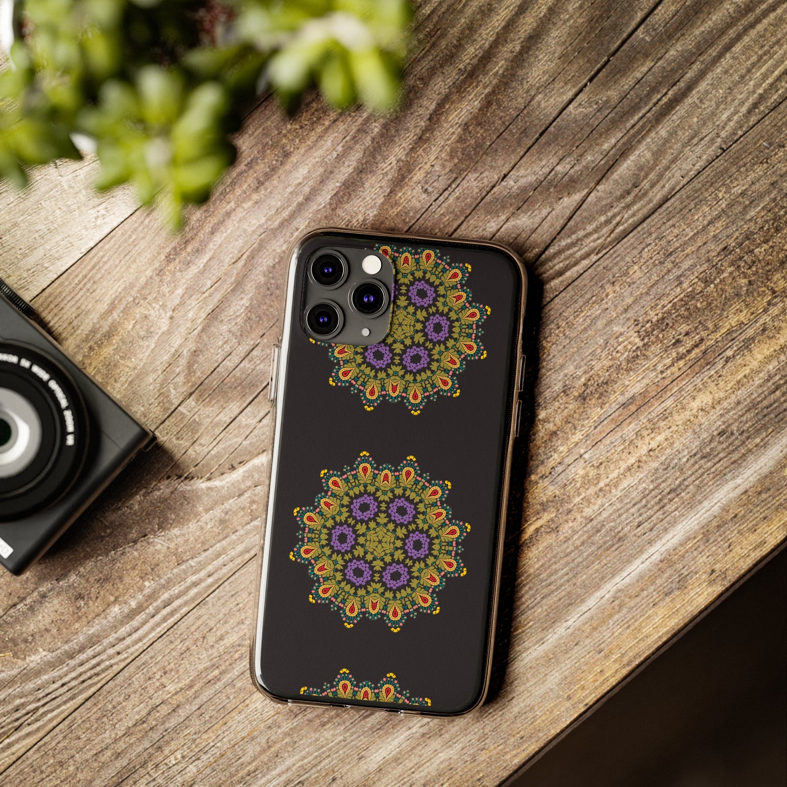 Gold mandala phone case on a wooden table, perfect for outdoor adventures. Ideal for camping and style enthusiasts.