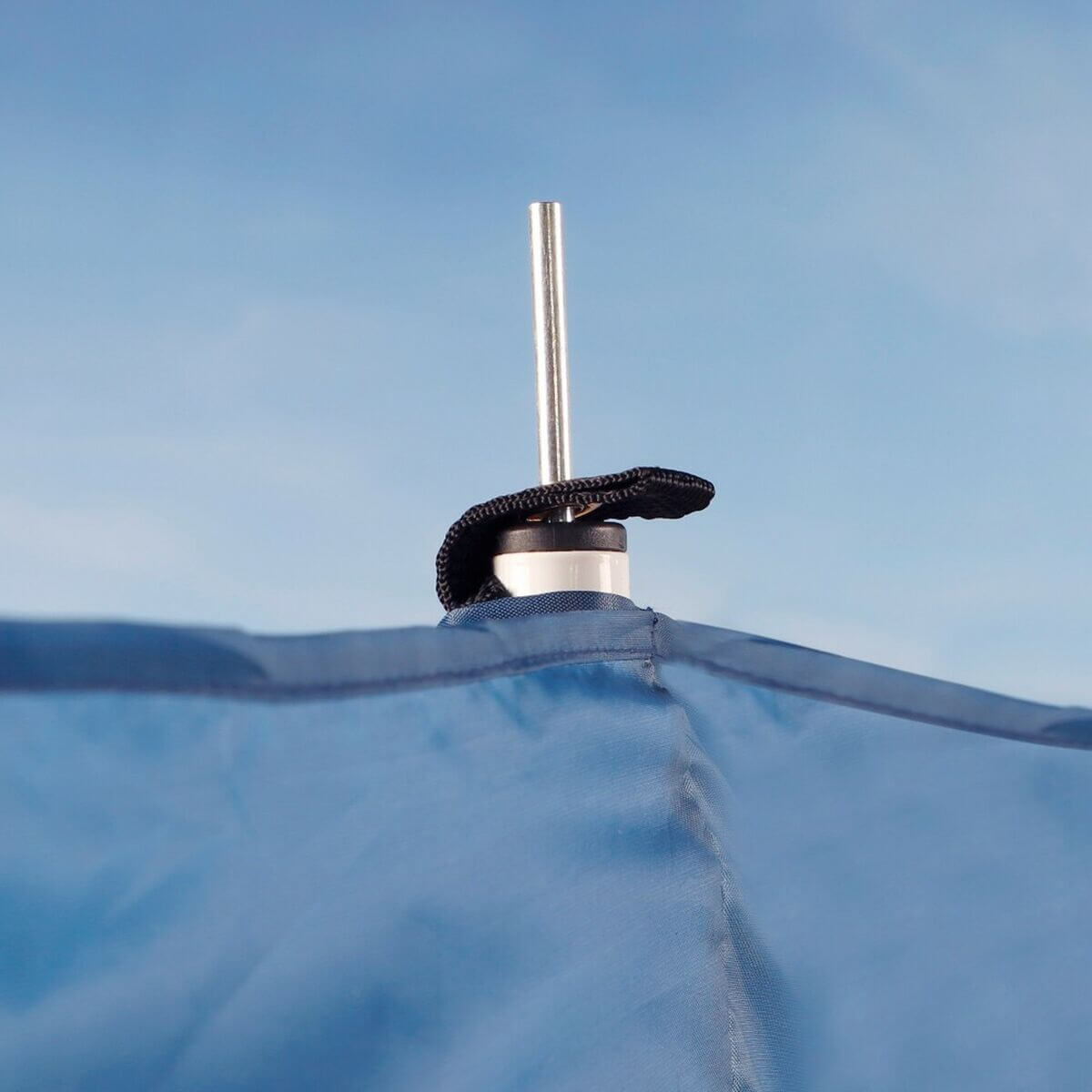 Close-up of a Beach Tent Aktive attachment showing stainless steel pole and fabric detail against a blue sky.