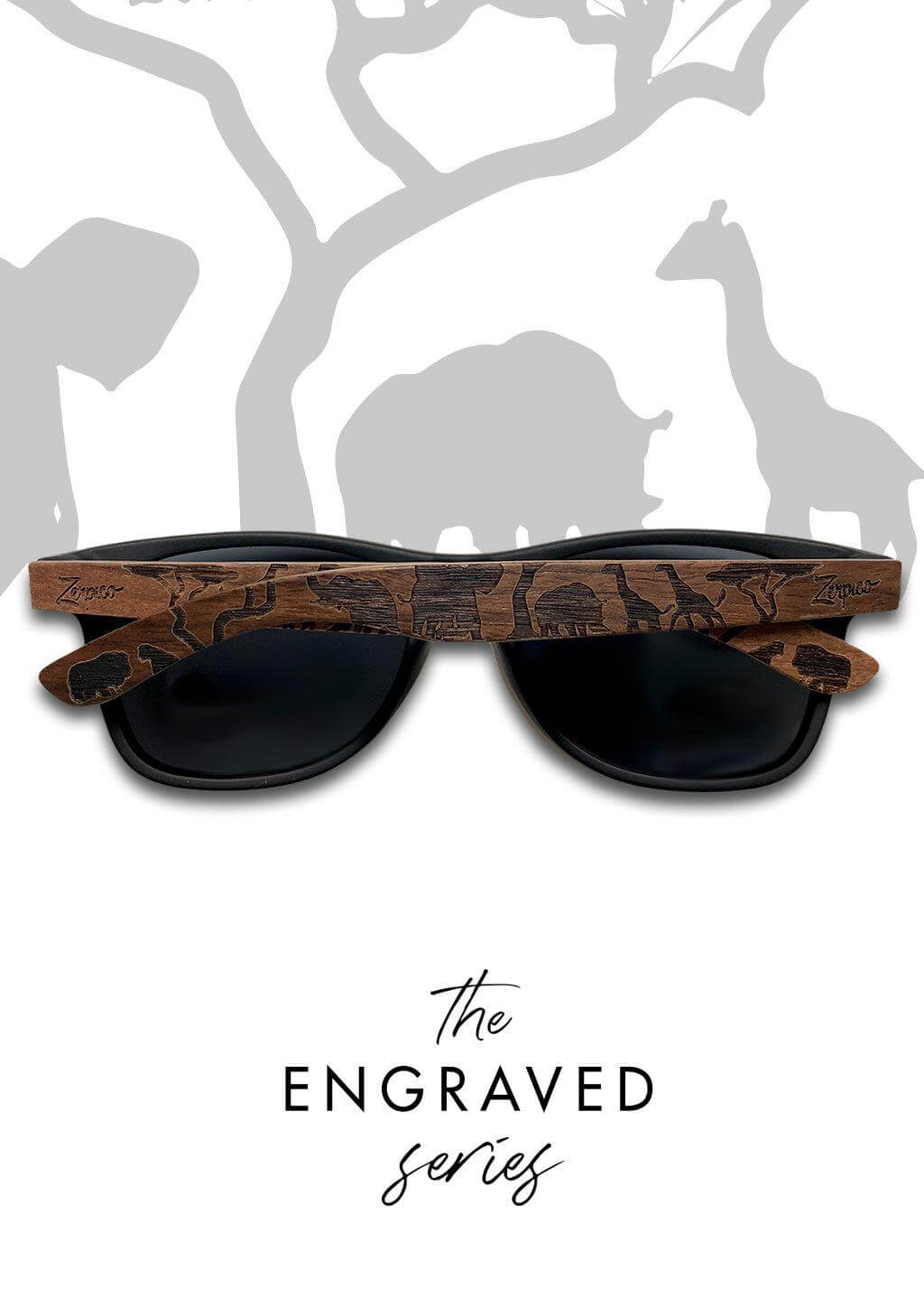 Engraved Eyewood Safari wooden sunglasses on green leaves, ideal for outdoor adventures and camping.
