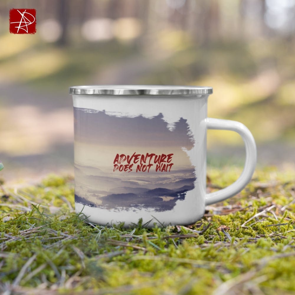 Adventure mug on grass, perfect for outdoor camping adventures. Durable enamel design from revlando.com.